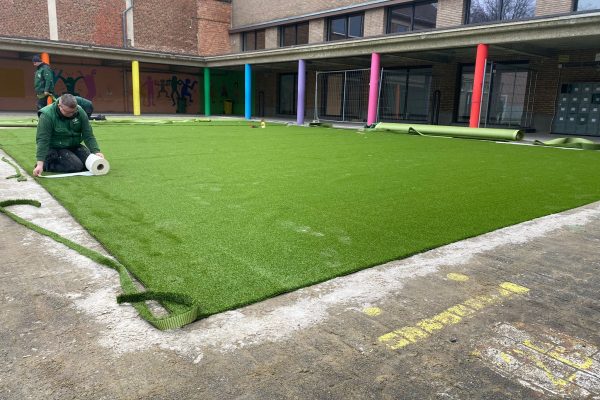Sfeerbeeld van een speelplaats die voorzien wordt van kunstgras