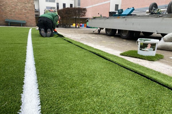 Sfeerbeeld van een speelplaats die voorzien wordt van kunstgras